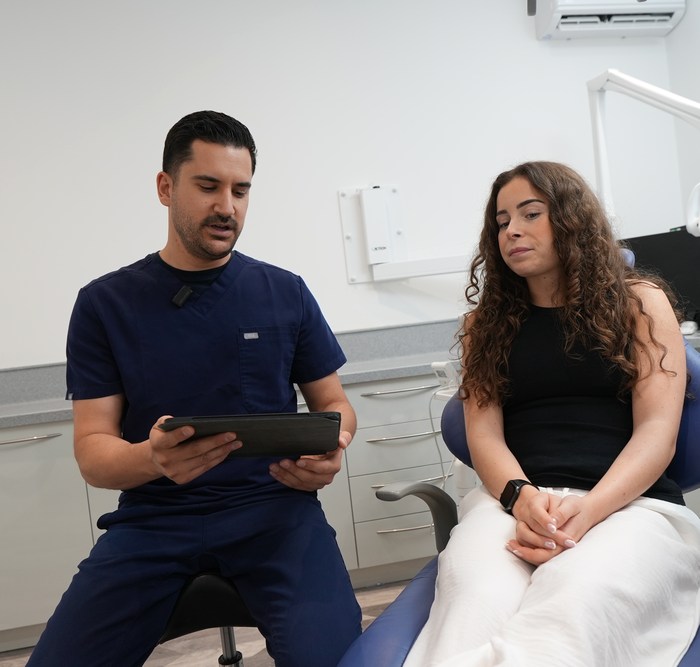 A dentist showing a patient their 3D scan at Elegant Smiles